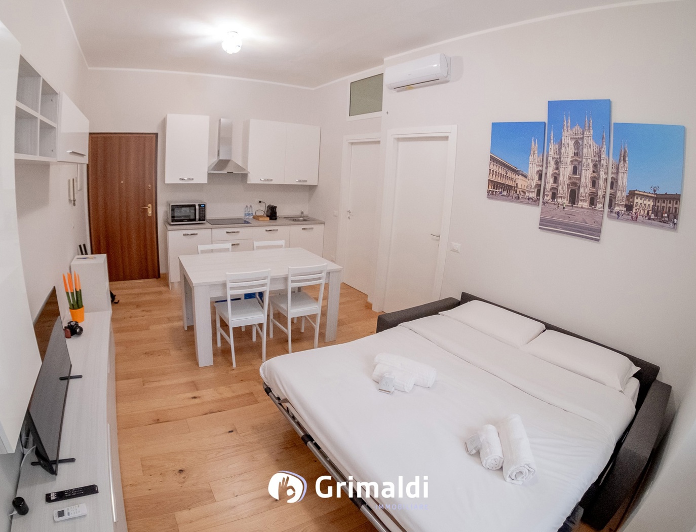 Area giorno con tavolo, divano-letto e cucina.jpg